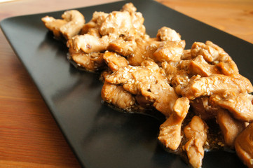 Chicken teriyaki in black plate vertical