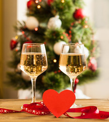 Two glasses with champagne and a red heart on the table, the celebration of Valentine's Day