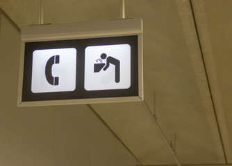 a call and drinking water point sign hanging on ceiling in a terminal airport