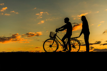 Fototapeta premium Silhouette of sweet couple in love happy time and bicycle in bea