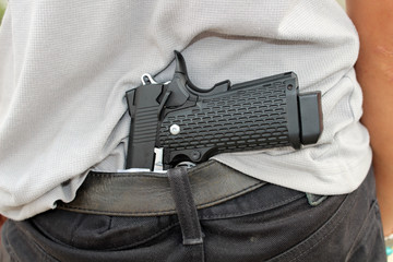 gangster concealing his gun behind his back