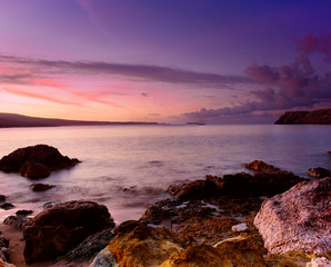 Beautiful colorful sunrise at the sea with dramatic clouds and boulders. Beauty world natural outdoors travel background