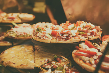 True italian pizza in the showcase of pizzeria in Florence, Italy. Food background.
