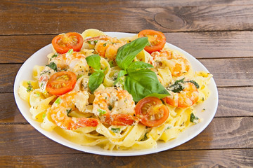 delicious fettuccine pasta with prawns on white plate