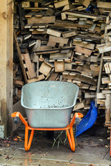 pile of wood logs with wheelbarrow
