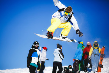 Plakat Jumping snowboarder on blue sky background