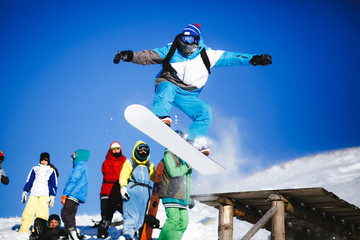 Jumping snowboarder on blue sky background