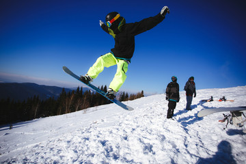 Jumping snowboarder on blue sky background