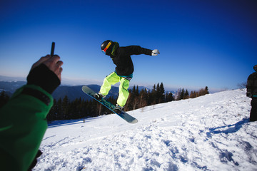 Jumping snowboarder on blue sky background