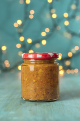 Jar of fruit butter on blurred festive background