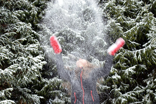 Young Woman Throwing Snow In The Air.