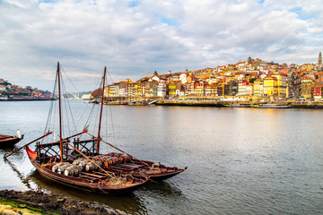 Obraz premium A view of boats transporting Porto wine with Porto in the background, Portugal