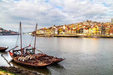 A view of boats transporting Porto wine with Porto in the background, Portugal