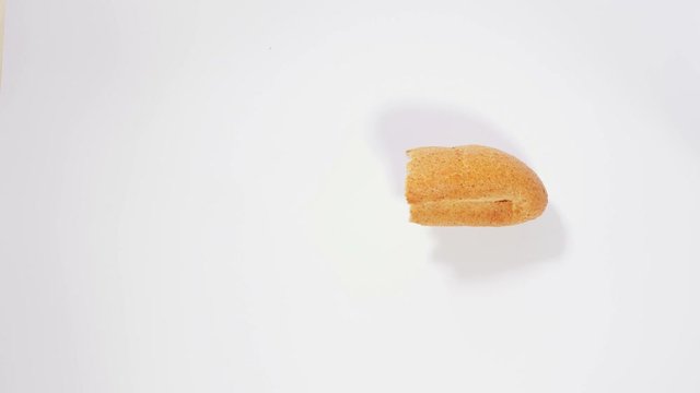Baguette disappears bite by bite on white background, eating bread, pastries, bakery, wheat bran, healthy food. Close up, stop motion, 4K Ultra HD.