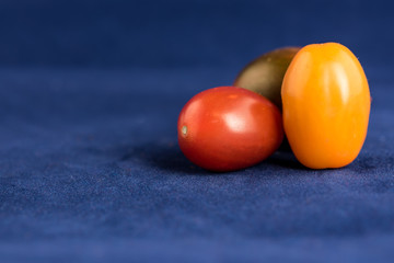 Fototapeta na wymiar Cherry Tomatoes close up with Blue background
