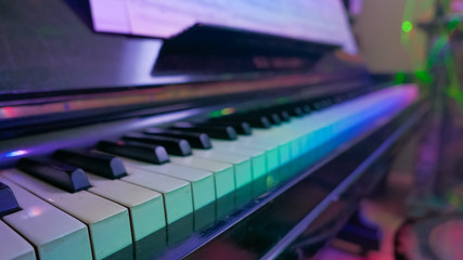 Close up of piano keys with colorful lights. Modern music concep