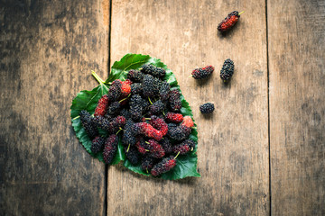 mulberry on leaf with wooden background