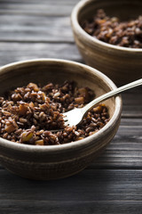 red rice in a clay plate. healthy diet. complex carbohydrates