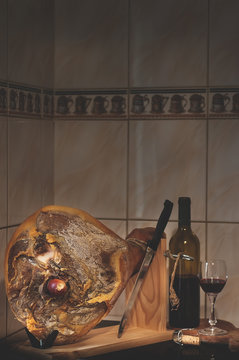 Spanish Jamon Serrano, wooden tabla jamonera, knife, glass and bottle of wine. Food photo concept