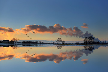 Piękne odbicie chmur, nieba i elektrowni w jeziorze, zimą. © Stanisław Błachowicz