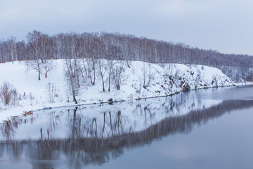 snow-covered river bank in winter