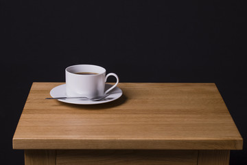 Time For Coffee / An image of a cup of black coffee sitting on an oak table.