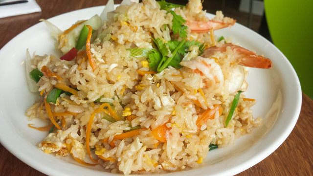 Shrimp fried rice , Asian food fried rice with prawns on in white dish on table.
