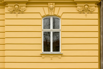 Retro looking window on a yellow facade