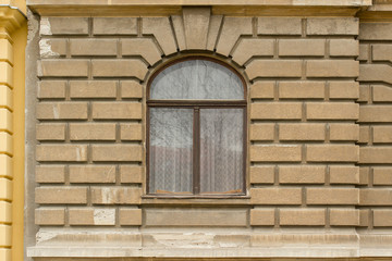 Retro looking window on a brown facade 