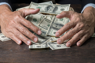 Man hands sweeping money,business concept.
Lucky man winning  lots of us dollar from gambling,with...