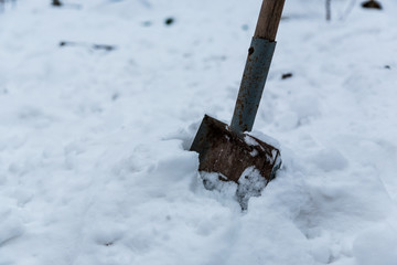 Old tired rusty garden shovel (scoop) in my backyard have relax in snow on the winter time.