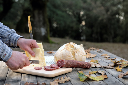 Outdoor eating with bread, cheese and sausage.
