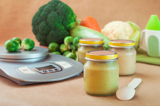 Glass jar with baby food near kitchen scales