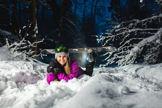 Portrait of the young sexy snowboarder in the dark winter forest