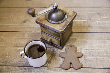 Manual vintage coffee grinder, cup of coffee and ginger biscuits