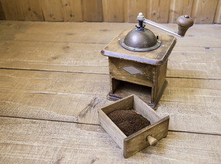 Vintage manual coffee grinder standing on a wooden surface