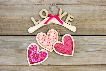 Pink hearts hanging from hanger with LOVE