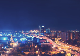 Fototapeta na wymiar Bright streetlights and traffic at night in city
