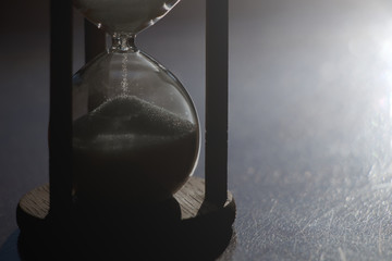 Hourglass time passing in contrast backlit. sandglass in sunlight 