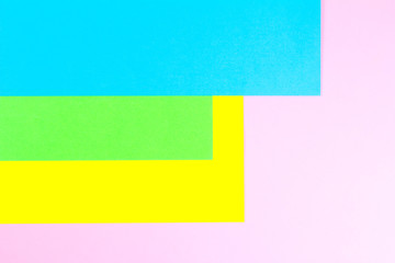 Material design yellow, blue, pink and green paper background. Photo.