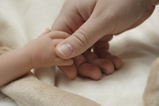 a mother holding a baby's hand