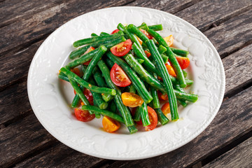 Green beans salad with Red, Yellow Tomatoes on white plate
