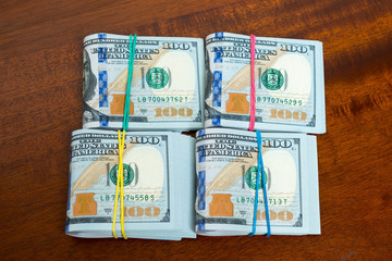 Obraz premium Stashes of hundred dollar bills on wooden table