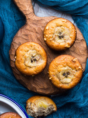 Freshly baked home made spiced banana muffins with walnuts on wooden serving board on rustic table. Healthy snack for children. Vertical image