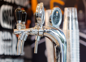 shining beer faucets in a bar / Metallic beer taps / Beer tap at - obrazy, fototapety, plakaty