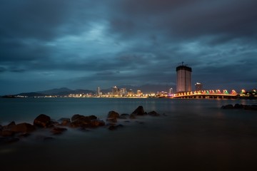 Nha Trang holiday resort skyline Vietnam slow exposure over the bay just after sunset with the city lights ablaze.