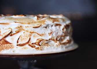 Delicious cake on stand and blurred background