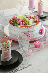 Delicious cake decorated with flowers on blurred background