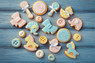 Baby cookies decorated with glaze on wooden background