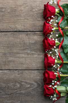 Roses on wooden board, background, copy space.